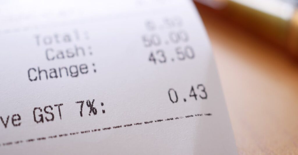 Detailed close-up image of a shopping receipt showing GST and total changes.